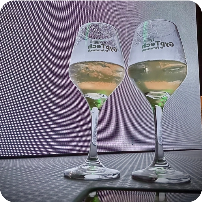 Brindis con copas de vidrio personalizadas con el logo de GypTech en un evento corporativo