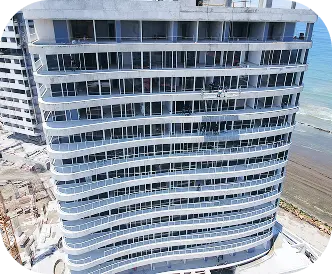Vista frontal de edificio curvo en la costa construido con sistema de paneles en seco – Gyptech