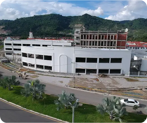 Vista aérea de la construcción de Plaza Comercial Galerías con estructura moderna y fondo montañoso